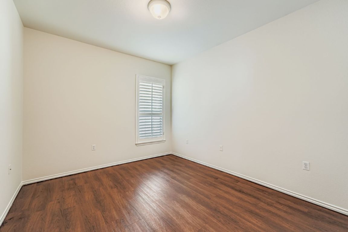 307 Mill Pond Path Georgetown, TX 78633 - Photo 19 of 26 Second bedroom featuring dark wood-style flooring and baseboards