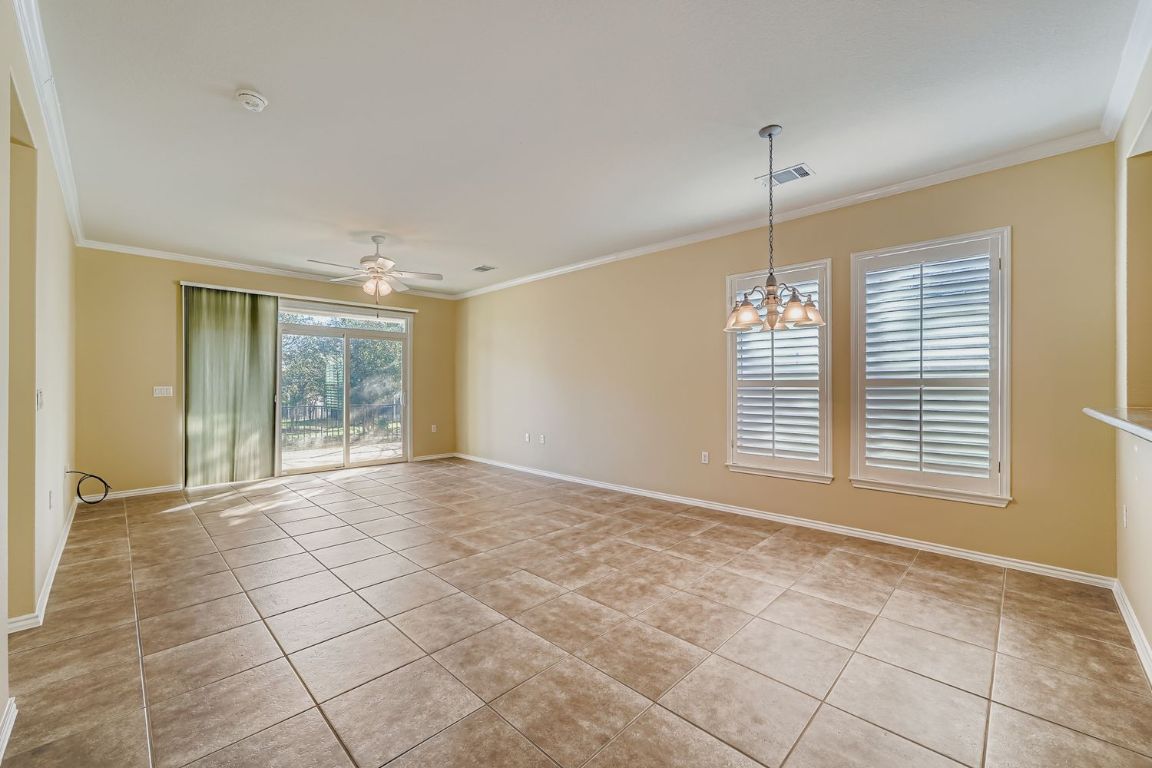 307 Mill Pond Path Georgetown, TX 78633 - Photo 5 of 26 View of the Family room with ornamental molding, a ceiling fan, light tile patterned floors, and a chandelier