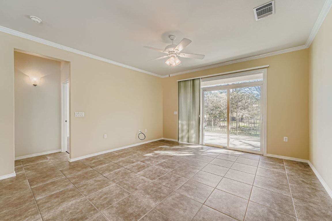 307 Mill Pond Path Georgetown, TX 78633 - Photo 6 of 26 Family room featuring crown molding, ceiling fan, and light tile patterned floors. View of Greenbelt outside.
