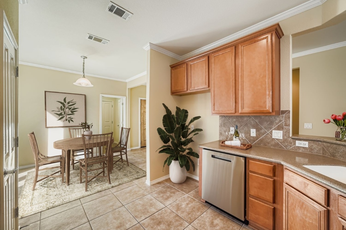 307 Mill Pond Path Georgetown, TX 78633 - Photo 10 of 26 Virtually staged Kitchen featuring dishwasher, tasteful backsplash, crown molding, decorative light fixtures, and light tile patterned flooring