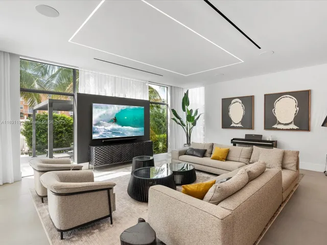a living room with furniture kitchen view and a large window