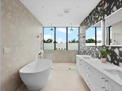 a bedroom with a bed painting on wall and a large window