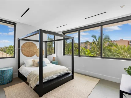 a living room with furniture a rug and a floor to ceiling window