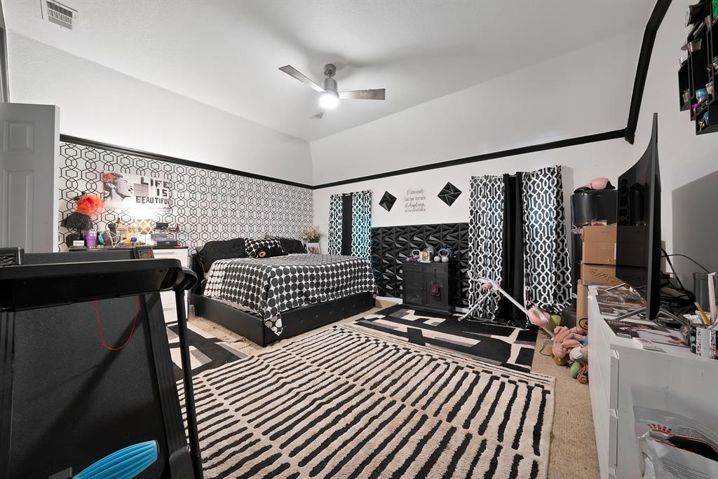 2716 Rochelle Point Irving, TX 75062 - Photo 14 of 40 Vented ceiling fan, vaulted ceiling, white walls, black accent trim, patterned wallpaper accent wall