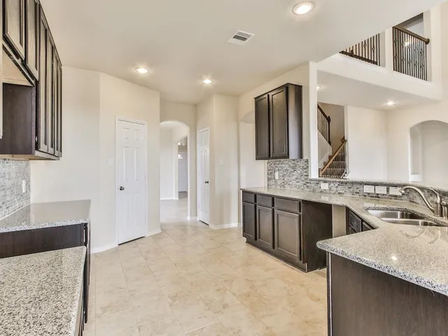 a bathroom with a granite countertop sink a large mirror and a shower
