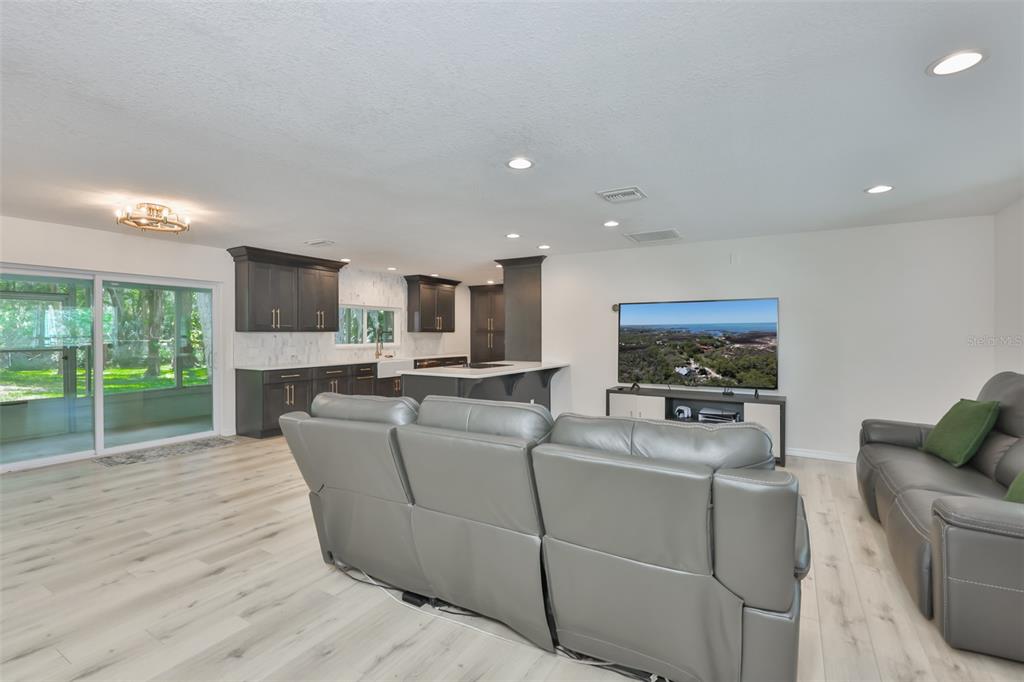 1578 Indian Bay Road Spring Hill, FL 34607 - Photo 9 of 51 a living room with furniture a flat screen tv and a fireplace