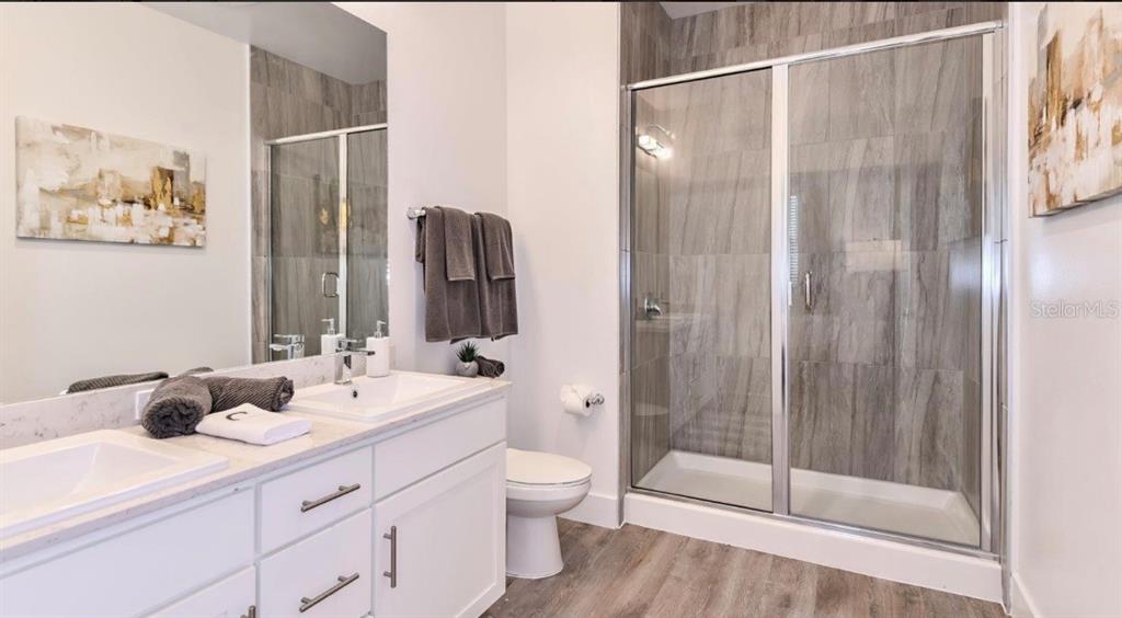 4802 Southwest 34th Place Gainesville, FL 32608 - Photo 2 of 5 a bathroom with a double vanity sink toilet and shower