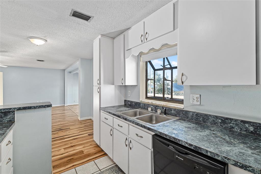 10577 Southeast 101st Avenue Road Belleview, FL 34420 - Photo 11 of 17 a kitchen with granite countertop a sink stove and cabinets