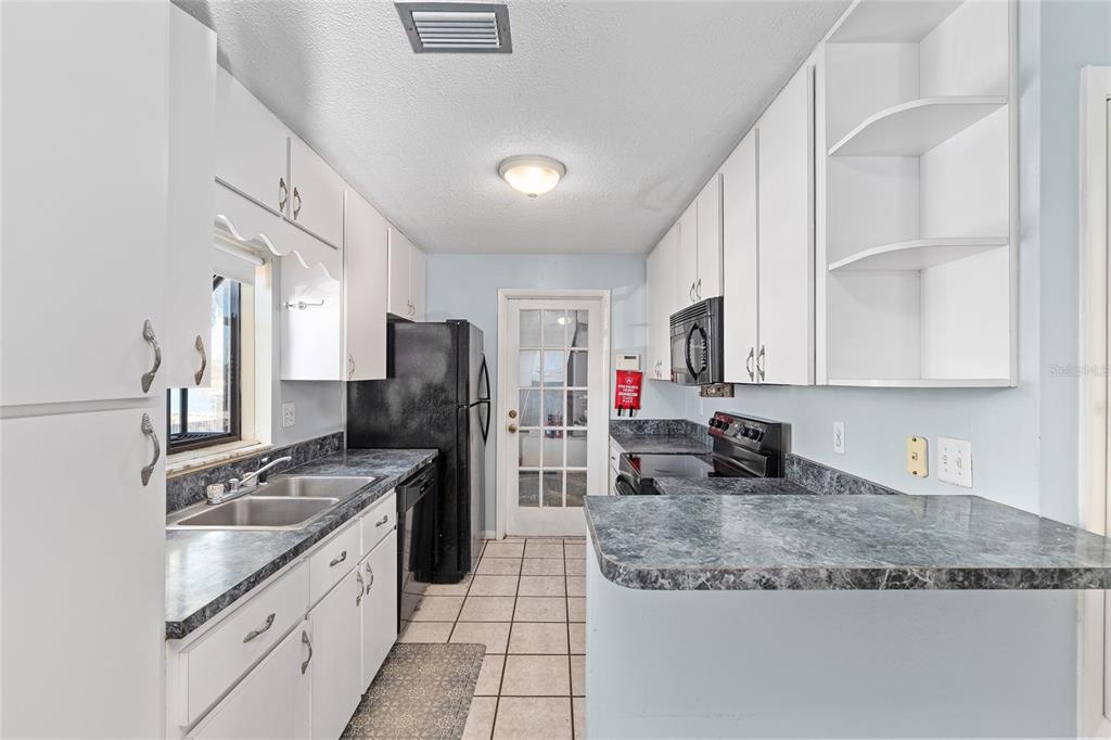 10577 Southeast 101st Avenue Road Belleview, FL 34420 - Photo 10 of 17 a kitchen with granite countertop a sink stainless steel appliances and white cabinets