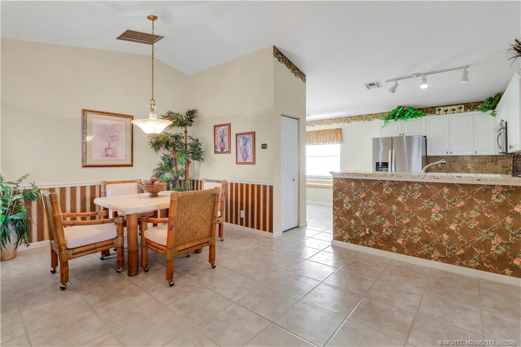 2698 Southwest Versailles Terrace Stuart, FL 34997 - Photo 11 of 29 a view of a dining room with furniture and a chandelier