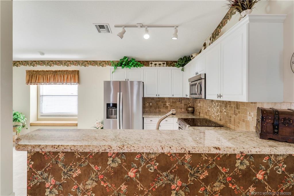 2698 Southwest Versailles Terrace Stuart, FL 34997 - Photo 14 of 29 a bathroom with a granite countertop sink and a mirror