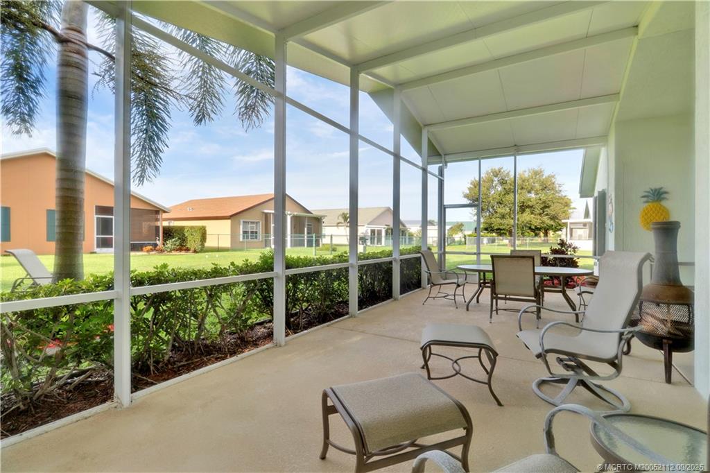 2698 Southwest Versailles Terrace Stuart, FL 34997 - Photo 28 of 29 a view of a patio with table and chairs potted plants with wooden floor and fence