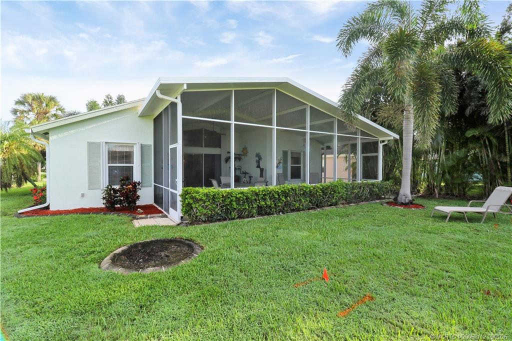 2698 Southwest Versailles Terrace Stuart, FL 34997 - Photo 29 of 29 a view of a house with backyard sitting area and garden