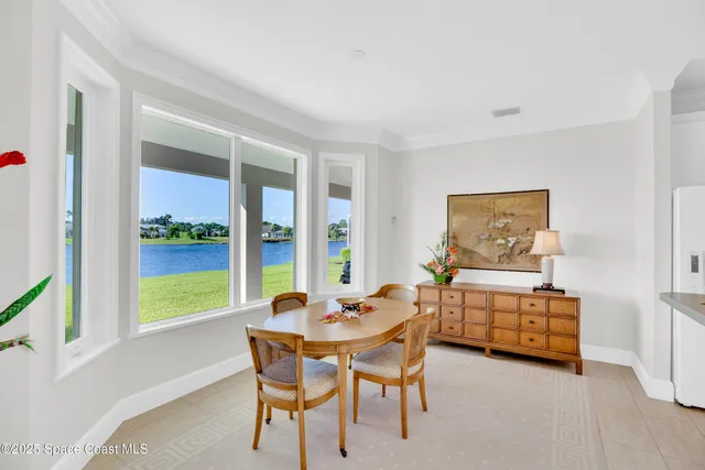 a dining room with furniture a rug and a floor to ceiling window