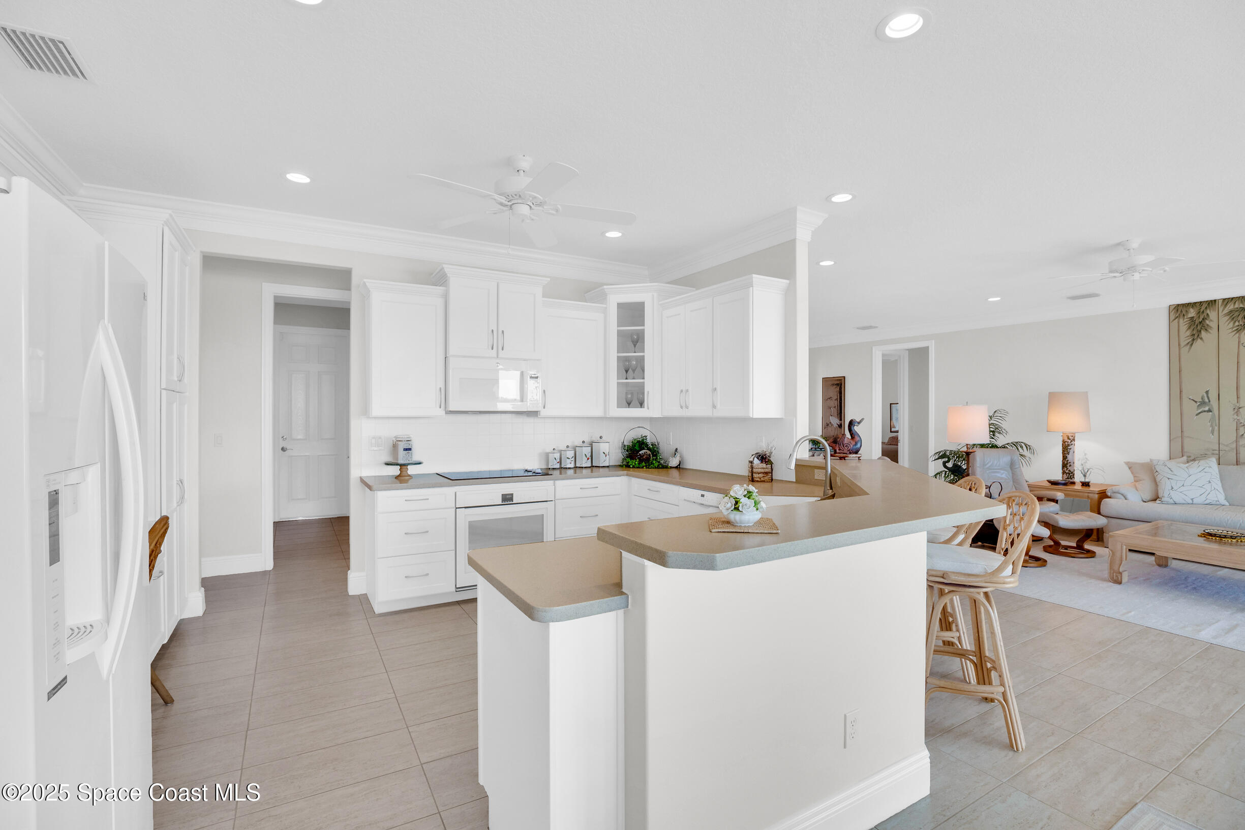 307 Yearling Trail Sebastian, FL 32958 - Photo 15 of 40 a kitchen with a sink a stove a refrigerator and white cabinets
