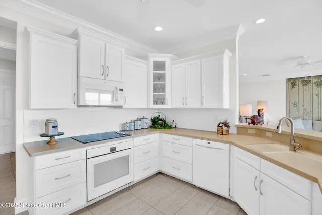 a kitchen with a sink dishwasher and white cabinets