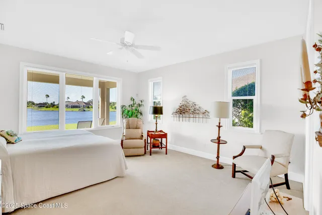 a bedroom with furniture and a large window
