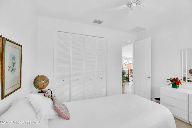 a bedroom with a bed a clock and a lamp on a table