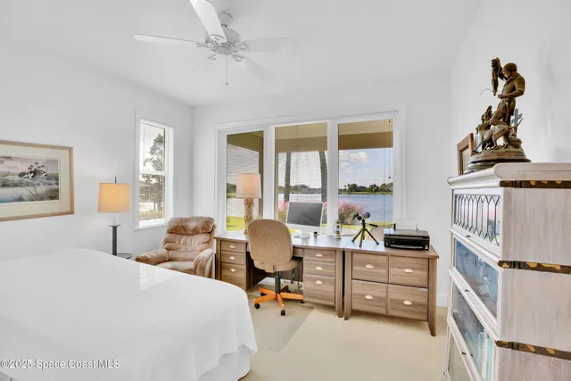 a bedroom with furniture and large windows