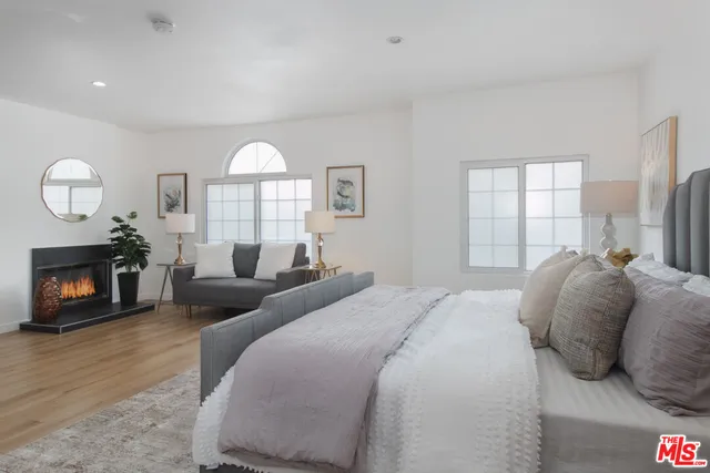 a spacious bedroom with a bed and a fireplace