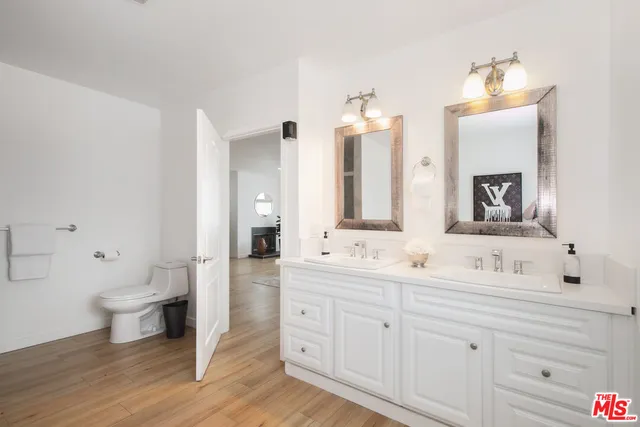 a bathroom with a double vanity sink mirror and toilet