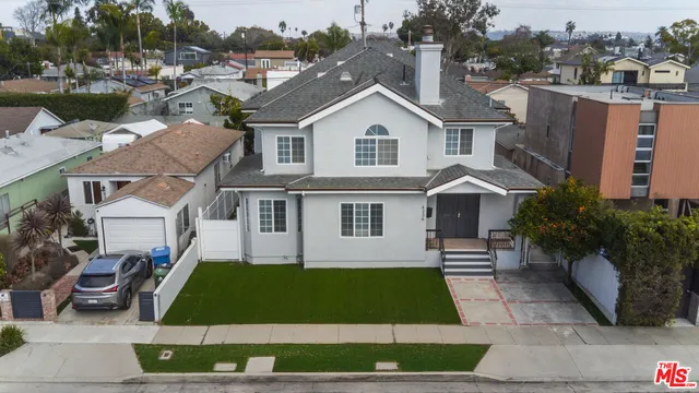 a front view of a house with a garden and plants