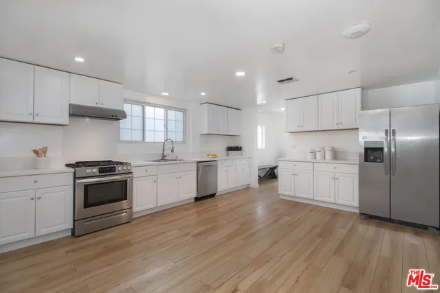 a kitchen with a stove a sink and a refrigerator