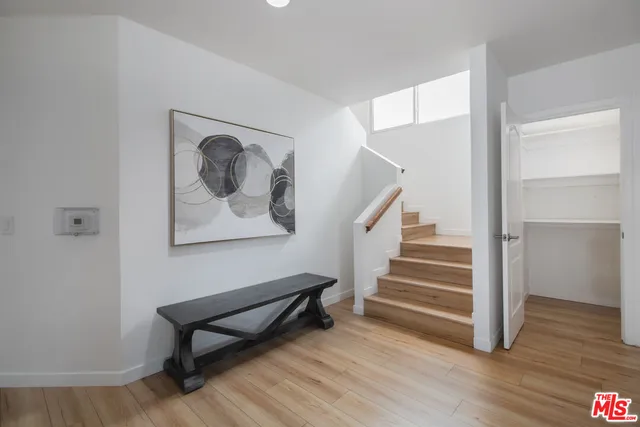 a view of a hallway with wooden floor and stairs