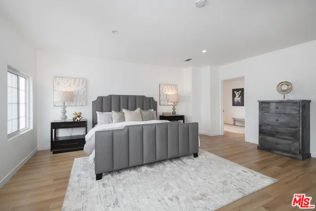 a bedroom with a bed and wooden floor