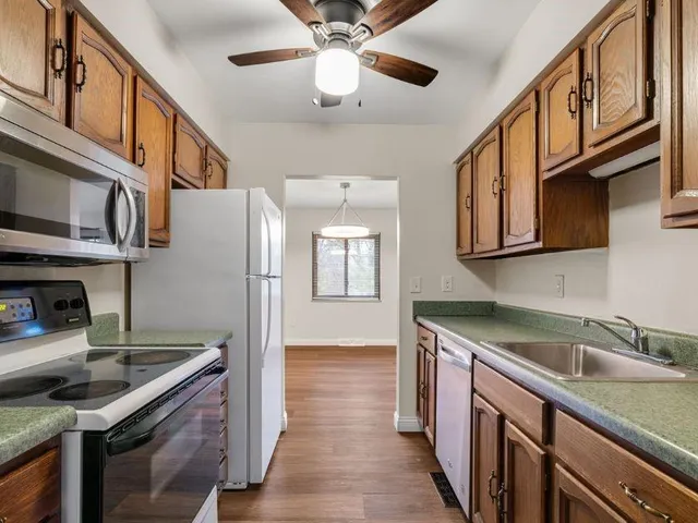 a kitchen with stainless steel appliances granite countertop a sink a stove and a refrigerator