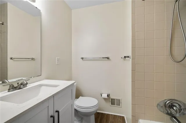 a bathroom with a sink a toilet and shower