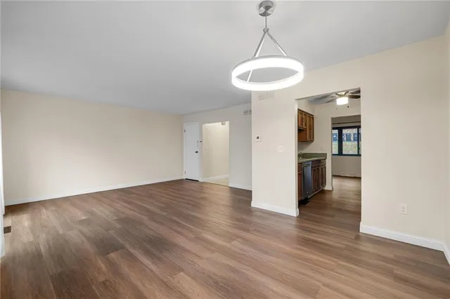 a view of a room with wooden floor a ceiling fan and window
