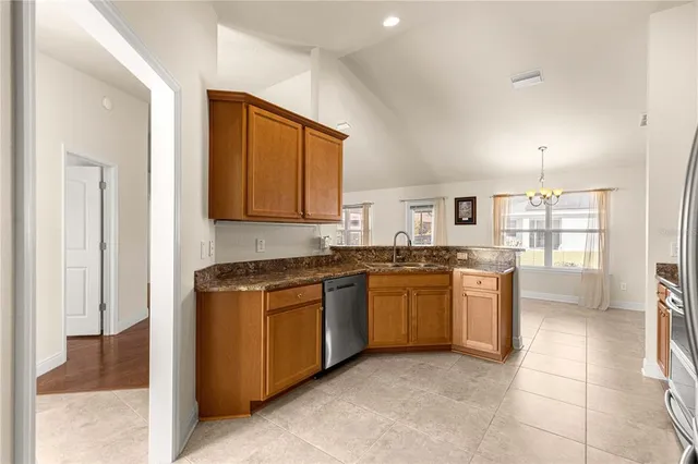 a kitchen with stainless steel appliances granite countertop a stove a sink and a refrigerator
