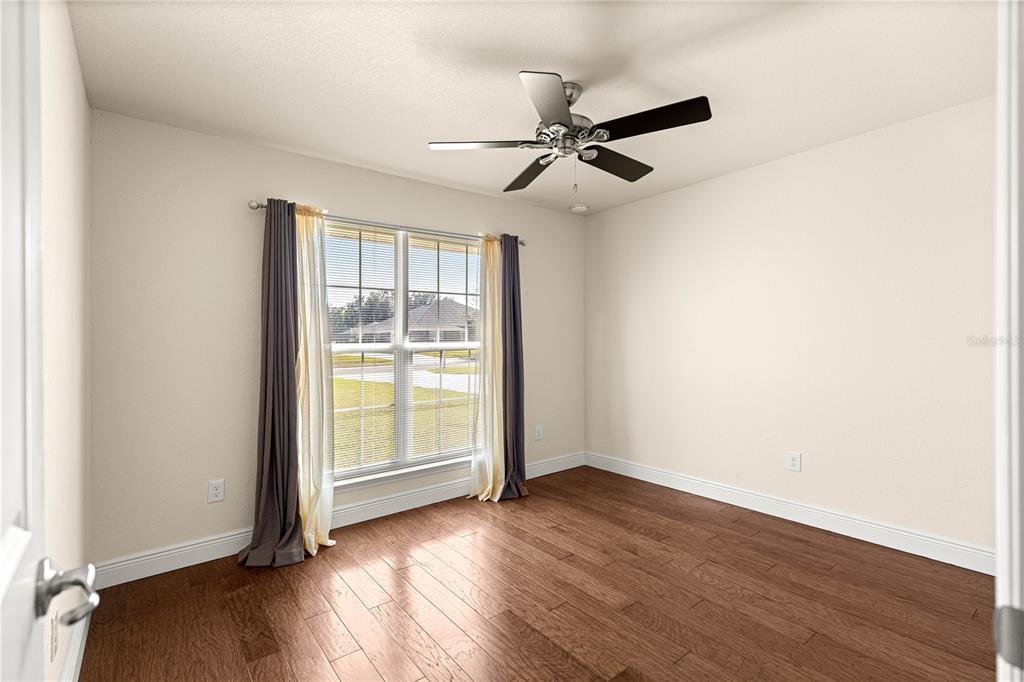 4401 Southwest 62nd Loop Ocala, FL 34474 - Photo 27 of 53 an empty room with wooden floor fan and windows