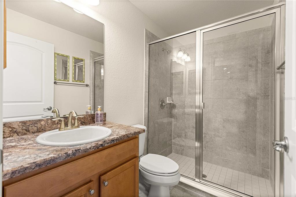 4401 Southwest 62nd Loop Ocala, FL 34474 - Photo 29 of 53 a bathroom with a granite countertop sink toilet and shower