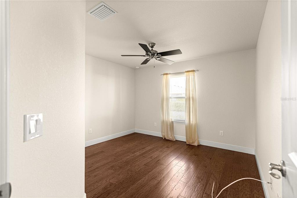 4401 Southwest 62nd Loop Ocala, FL 34474 - Photo 30 of 53 an empty room with wooden floor fan and windows