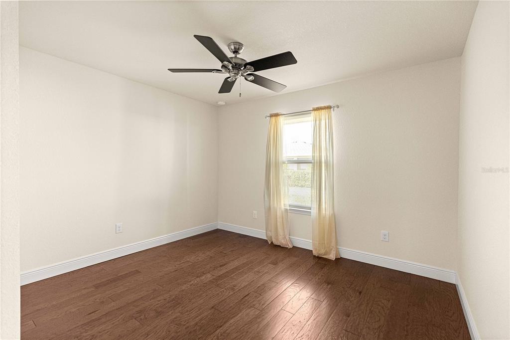 4401 Southwest 62nd Loop Ocala, FL 34474 - Photo 32 of 53 an empty room with wooden floor fan and windows