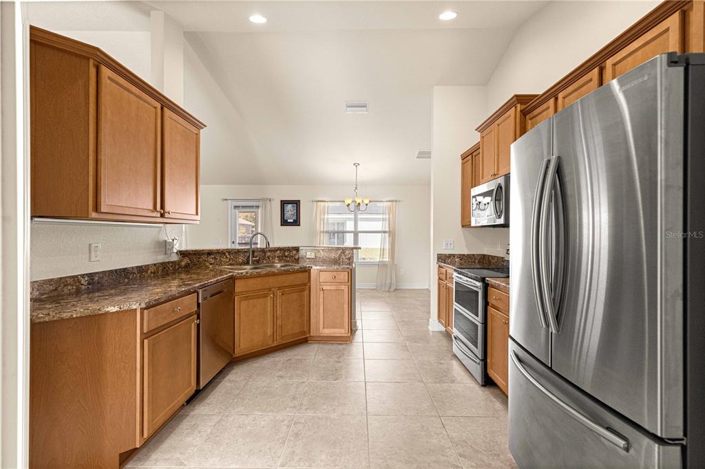 4401 Southwest 62nd Loop Ocala, FL 34474 - Photo 10 of 53 a kitchen with stainless steel appliances granite countertop a refrigerator and a stove top oven