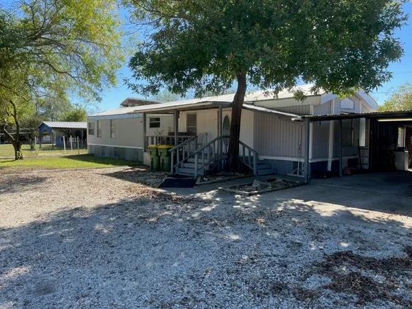 a view of a house with backyard and trees