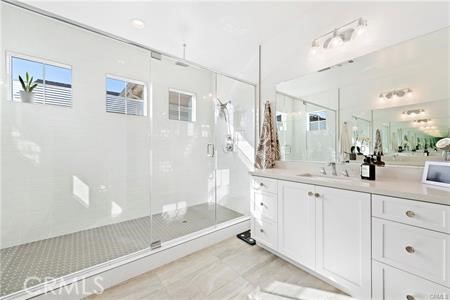 945 Sunlit Lane Costa Mesa, CA 92626 - Photo 21 of 31 a spacious bathroom with a shower a sink and a mirror