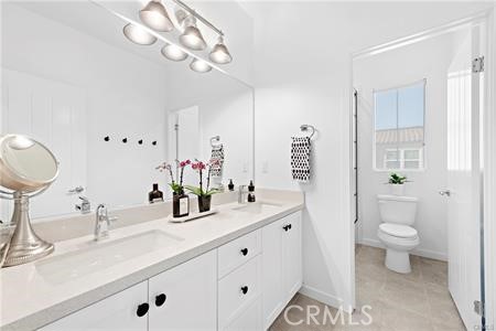 945 Sunlit Lane Costa Mesa, CA 92626 - Photo 27 of 31 a bathroom with a sink a toilet and a mirror