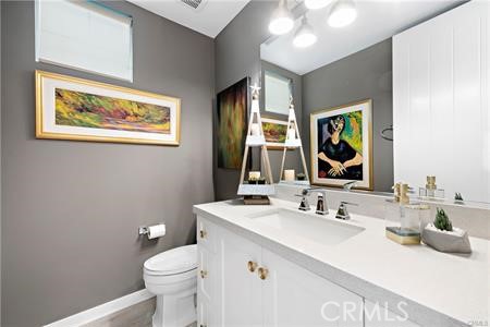 945 Sunlit Lane Costa Mesa, CA 92626 - Photo 28 of 31 a bathroom with a sink vanity mirror and toilet