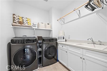 945 Sunlit Lane Costa Mesa, CA 92626 - Photo 29 of 31 a utility room with sink dryer and washer