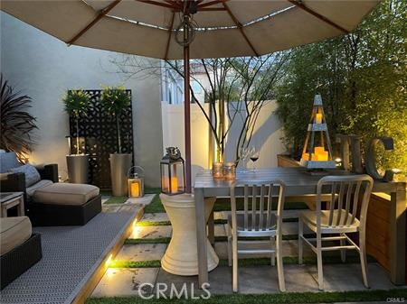 945 Sunlit Lane Costa Mesa, CA 92626 - Photo 31 of 31 a view of a patio with table and chairs under an umbrella