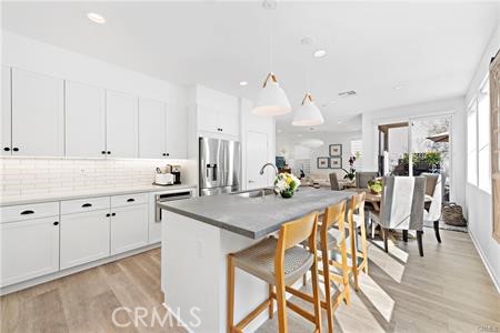 945 Sunlit Lane Costa Mesa, CA 92626 - Photo 6 of 31 a kitchen with granite countertop white cabinets and chairs
