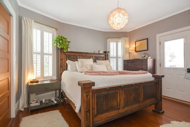 a spacious bedroom with a large bed and a chandelier