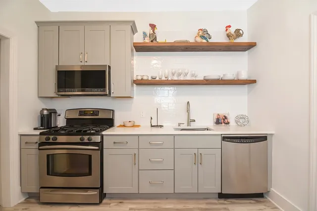 a kitchen with stainless steel appliances a stove and a microwave