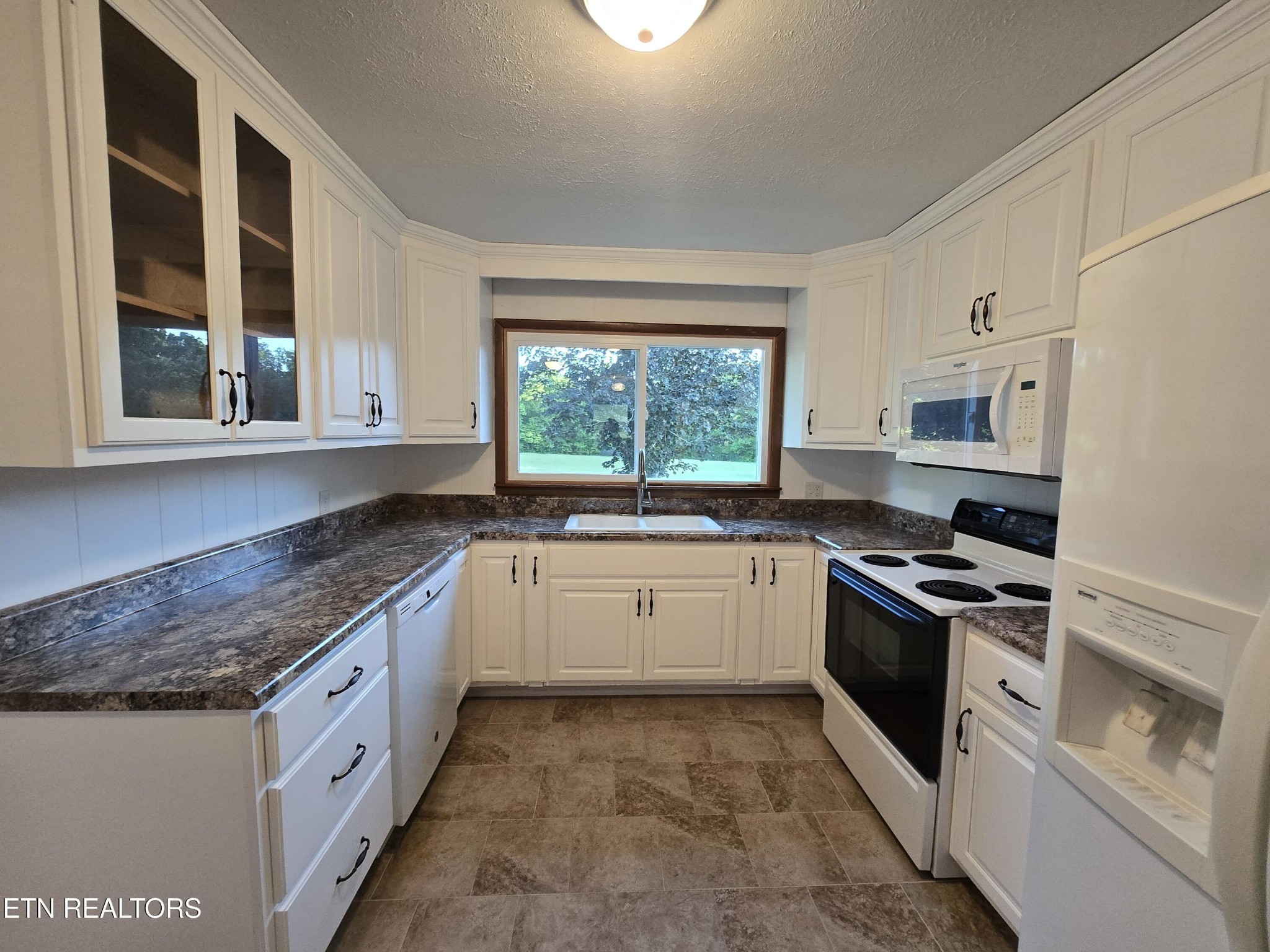 295 Bilbrey Road Crossville, TN 38571 - Photo 9 of 32 a kitchen with stainless steel appliances granite countertop a stove a sink and a microwave