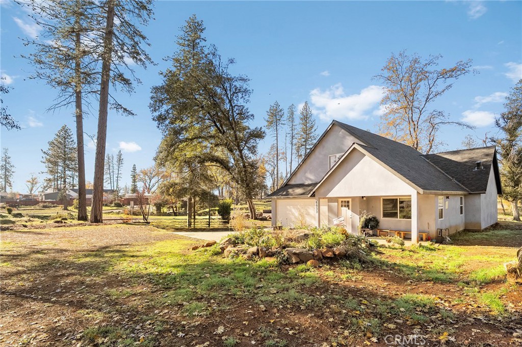 6033 Pentz Road Paradise, CA 95969 - Photo 12 of 54 a backyard of a house with table and chairs under an umbrella