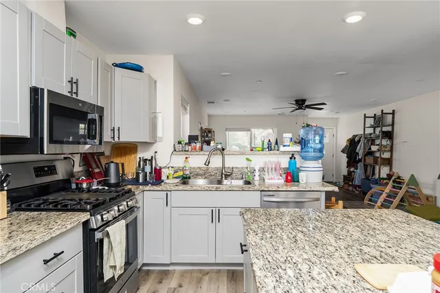 a kitchen with kitchen island granite countertop a sink a stove and refrigerator